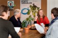 culturele apotheek foto 4 mensen aan tafel 1 senior en een jongere dame die vrolijk kijkt